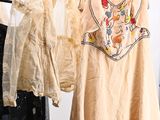 two women ' s dresses hanging on a clothes rack in a room