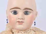 a close up of a doll with a bald head and blue eyes