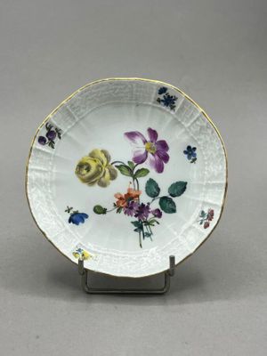 a white plate with flowers on it on a stand