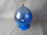 a blue glass vase with a gold top on a stand