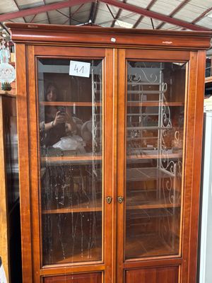 une grande armoire en bois avec des portes vitrées dans un magasin
