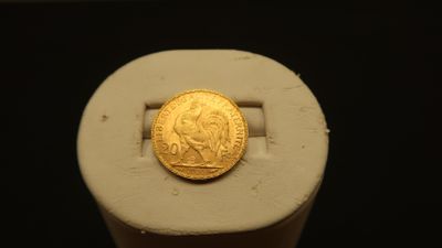 an image of a gold coin sitting on top of a white stand