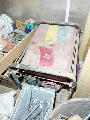 un lit posé au milieu d'un tas de bric-à-brac