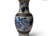 un vase bleu et blanc posé sur une surface blanche