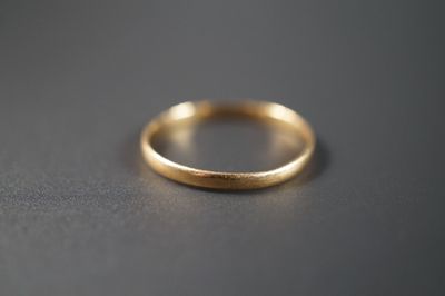 gros plan d'une bague en or sur une surface noire