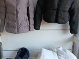 deux manteaux suspendus à un portant dans un magasin de vêtements