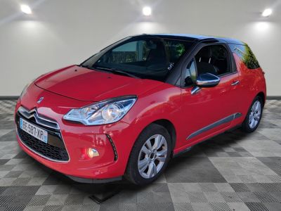 une Citrole rouge garée dans un garage au sol en damier
