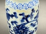 a blue and white vase with a yellow top