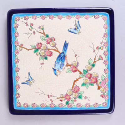 un oiseau bleu perché sur une assiette bleue et blanche