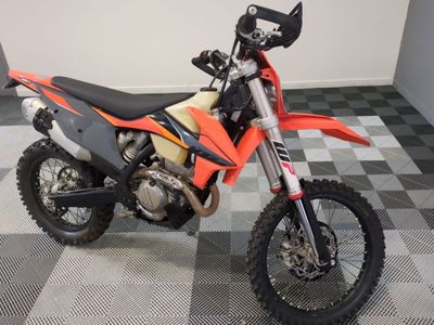 a dirt bike that is parked on a checkered floor