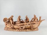 figurines sculptées représentant des personnes dans un bateau sur un plan d'eau