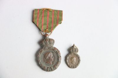 deux médailles et une médaille sur une surface blanche