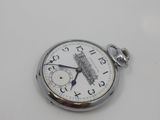 a silver pocket watch sitting on a white surface
