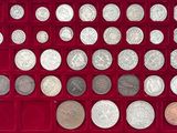 un assortiment d'objets en argent et de pièces d'argent présentés dans une vitrine rouge