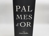 une bouteille de vin posée sur une table à côté d'un verre
