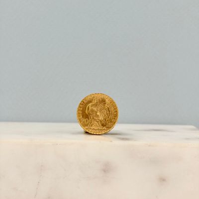 une pièce d'or posée sur un plan de travail en marbre blanc