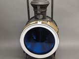 une lampe bleue posée sur un support métallique
