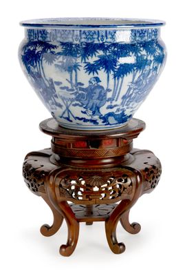 un bol bleu et blanc posé sur un socle en bois