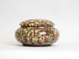 a small jar with a lid sitting on a white surface