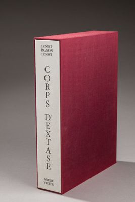 un livre rouge posé sur une table près d'un mur gris