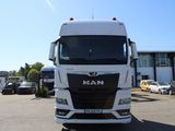 un camion blanc garé sur un parking à côté d'un immeuble