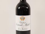 a bottle of red wine sitting on top of a white table