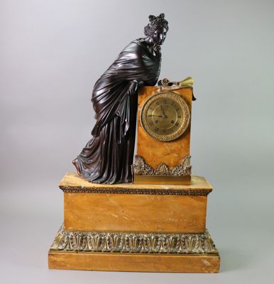 a statue of a woman sitting on top of a clock