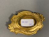 an antique gold plate with a label on it on a table