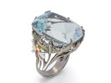 a close up of a ring on a white surface with a blue topaz
