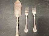 three forks and a spoon on a table