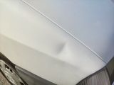 a white car that has a dent in the front of it