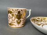 a cup and saucer sitting next to each other on a table