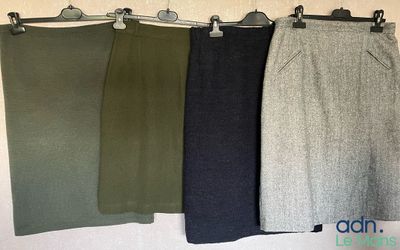 three pairs of skirts hanging on a wall in a row