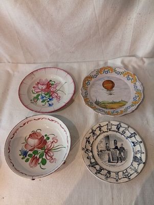 quatre assiettes ornées de motifs différents, posées sur une nappe blanche