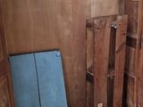 a wooden cabinet with a blue seat in the corner