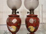 deux vases rouges exposés sur une étagère en verre