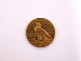 a gold coin with a bird on it on a white surface