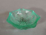 a green glass bowl with a flower inside of it