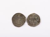 two silver coins, one of which has a crown on it and the other of which has a crown on