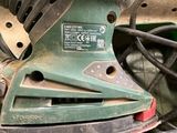 a sander sitting on top of a table next to a pile of wires