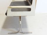 a black and white chair that is on a metal stand