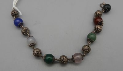 un gros plan d'un collier posé sur une table, avec un ruban blanc