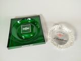 un cendrier en verre vert et un cendrier en verre transparent posés sur une table blanche
