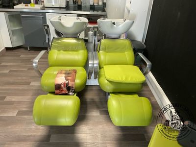 four green chairs in a room with a sink and a mirror