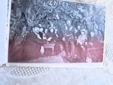 une vieille photo montrant un groupe de personnes assises sur un banc