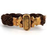 un gros plan sur un bracelet tressé muni d'un fermoir doré