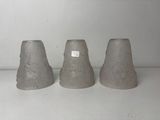three cement vases sitting on a shelf next to each other