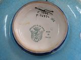 a blue and white plate with a picture of a coat of arms on it