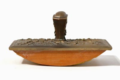 une statue en bronze représentant un homme assis sur un bateau