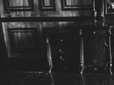 black and white photograph of a table with a vase of flowers on top of it